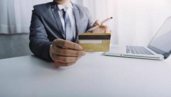 technology, people and online shopping concept - happy smiling man with tablet pc computer and credit card at home photo