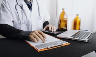 Medicine doctor hand working on a patients x-ray scans digital healthcare and connection with modern virtual screen interface icons, Medical technology and network concept. photo