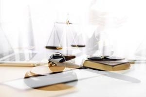 Justice and law concept.Male judge in a courtroom with the gavel, working with, computer and docking keyboard, eyeglasses, on table in morning light photo