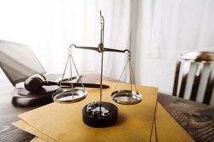 Justice and law concept.Male judge in a courtroom with the gavel, working with, computer and docking keyboard, eyeglasses, on table in morning light photo