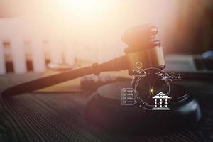 Justice and law concept.Male judge in a courtroom with the gavel, working with, computer and docking keyboard, eyeglasses, on table in morning light photo