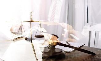 Justice and law concept.Male judge in a courtroom with the gavel, working with, computer and docking keyboard, eyeglasses, on table in morning light photo