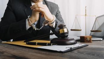 Business and lawyers discussing contract papers with brass scale on desk in office. Law, legal services, advice, justice and law concept picture with film grain effect photo