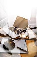 Justice and law concept.Male judge in a courtroom with the gavel, working with, computer and docking keyboard, eyeglasses, on table in morning light photo