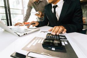 Business accounting concept, Business man using calculator with computer laptop, budget and loan paper in office. photo