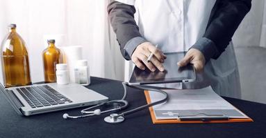 Medicine doctor hand working on a patients x-ray scans digital healthcare and connection with modern virtual screen interface icons, Medical technology and network concept. photo