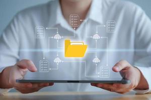sistema de gestión de documentos: dms, base de datos de documentación en línea y proceso para administrar archivos de manera eficiente. tecnología de la nube almacenamiento de datos. tableta manual para buscar carpetas y documentos desde la nube. foto