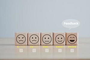 Business or customer service rating experience and feedback emotion and satisfaction survey concept. wood cube. satisfaction survey with star and negative, neutral and positive facial expressions. photo