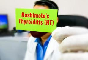 Hashimoto's Thyroiditis word on a card in doctor's hand, medical term word with medical concepts. photo