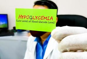 Hypoglycemia, medical term. Scientist hold card with text Hypoglycemia. Low blood sugar level. photo