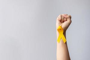 día de prevención del suicidio, infancia, sarcoma, mes de concientización sobre el cáncer de huesos y vejiga, cinta amarilla para apoyar la vida y la enfermedad de las personas. cuidado de la salud infantil y concepto del día mundial del cáncer foto