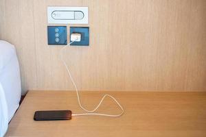 mobile smartphone charging battery on table at home or office. Technology, multiple sharing and recharge concepts photo