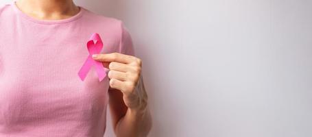 Pink October Breast Cancer Awareness month, woman hand hold pink Ribbon and wear shirt for support people life and illness. National cancer survivors month, Mother and World cancer day concept photo