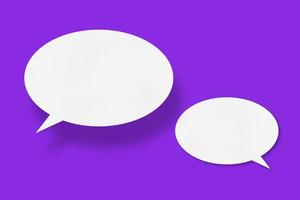 White paper in the shape of speech bubbles against a purple background. communication bubbles photo
