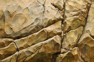 Light coarse natural rock stone background. Mining cliff rough front surface. Big limestone stack backdrop. Heavy grunge damaged granite block texture photo