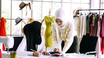 hermosas mujeres musulmanas trabajando juntas en la oficina de ropa. foto
