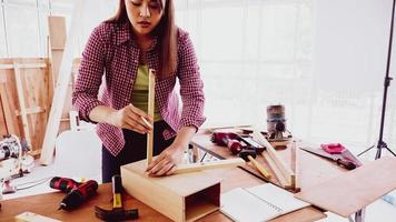 Female carpenter fitting pieces of boards together at site. photo