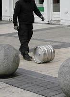 Man rolling a keg of beer through the streets photo