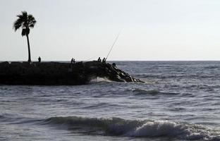 hombres en cuba pescando en la costa foto