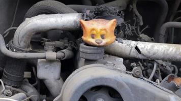 kaputtes auto nach einem verkehrsunfall. Autoversicherungskonzept. kaputtes und beschädigtes Auto. ein Spielzeug in einem ausgebrannten Auto zwischen Ersatzteilen und Rohren. ukraine, irpin - 24. mai 2022. video