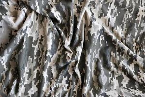 Fabric with texture of Ukrainian military pixeled camouflage. Cloth with camo pattern in grey, brown and green pixel shapes. Official uniform of Ukrainian soldiers photo