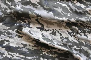 Fabric with texture of Ukrainian military pixeled camouflage. Cloth with camo pattern in grey, brown and green pixel shapes. Official uniform of Ukrainian soldiers photo