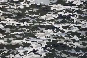 Fabric with texture of Ukrainian military pixeled camouflage. Cloth with camo pattern in grey, brown and green pixel shapes. Official uniform of Ukrainian soldiers photo