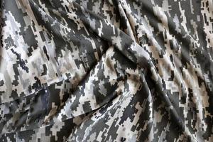 Fabric with texture of Ukrainian military pixeled camouflage. Cloth with camo pattern in grey, brown and green pixel shapes. Official uniform of Ukrainian soldiers photo