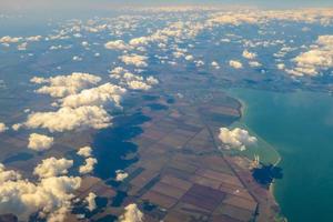 Aerial photo of Farmland. view from the plane to the ground. squares of fields under the clouds