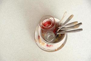 Stack of dirty dishes with food leftovers on the table after meal. Banquet ending concept. Unwashed dishes photo