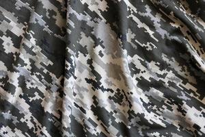 Fabric with texture of Ukrainian military pixeled camouflage. Cloth with camo pattern in grey, brown and green pixel shapes. Official uniform of Ukrainian soldiers photo