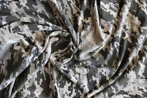 Fabric with texture of Ukrainian military pixeled camouflage. Cloth with camo pattern in grey, brown and green pixel shapes. Official uniform of Ukrainian soldiers photo