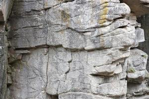 Light coarse natural rock stone background. Mining cliff rough front surface. Big limestone stack backdrop. Heavy grunge damaged granite block texture photo