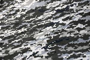 Fabric with texture of Ukrainian military pixeled camouflage. Cloth with camo pattern in grey, brown and green pixel shapes. Official uniform of Ukrainian soldiers photo