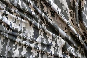 Fabric with texture of Ukrainian military pixeled camouflage. Cloth with camo pattern in grey, brown and green pixel shapes. Official uniform of Ukrainian soldiers photo