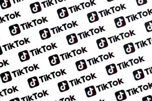 Many TikTok logo printed on paper. Tiktok or Douyin is a famous Chinese short-form video hosting service owned by ByteDance photo