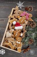 Galletas de jengibre de Navidad caseras en mesa de madera. foto