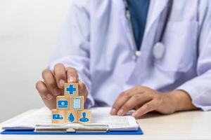 Hand holding wooden cubes block with insurance health car medical symbol on background and copy space. photo