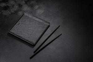 Empty square black plate on dark moody background with copy space photo