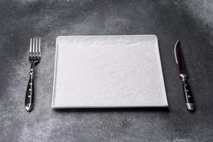 Empty square white plate on a gray moody background with copy space photo