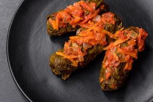 Dolma, stuffed grape leaves with rice and meat on a dark background photo