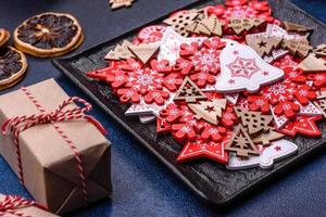 adornos navideños y panes de jengibre en una mesa de hormigón oscuro. preparándose para la celebración foto