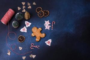 adornos navideños y panes de jengibre en una mesa de hormigón oscuro foto