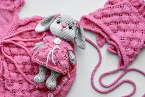 Beautiful baby knitted clothes and a toy for a newborn baby photo