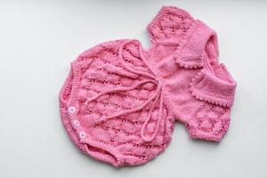 Beautiful baby knitted clothes and a toy for a newborn baby photo