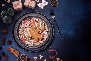 adornos navideños y panes de jengibre en una mesa de hormigón oscuro. preparando y decorando la casa para las vacaciones foto