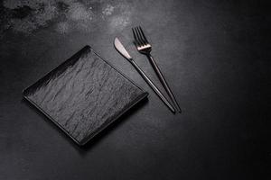 Empty square black plate on dark moody background with copy space photo