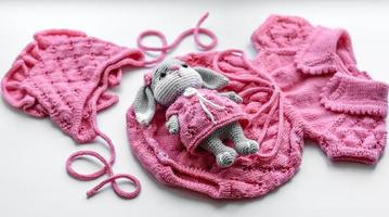 Beautiful baby knitted clothes and a toy for a newborn baby photo