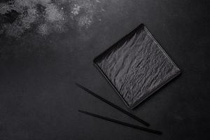 Empty square black plate on dark moody background with copy space photo
