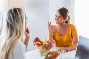 Professional nutritionist meeting a patient in the office. young smiling female nutritionist in the consultation room. Nutritionist desk with healthy fruit and measuring tape. photo